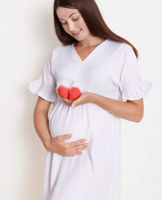 pregnant-happy-woman-holding-red-knitted-baby-shoes-her-hands-touching-her-belly-with-charming-smile